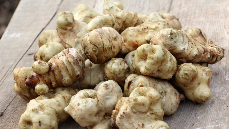 Sunchokes piled on a wood background