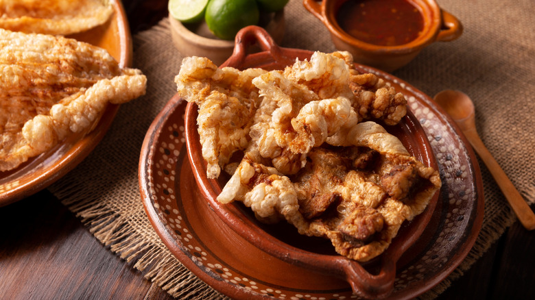 Pork rinds in a dish with a side of spicy sauce