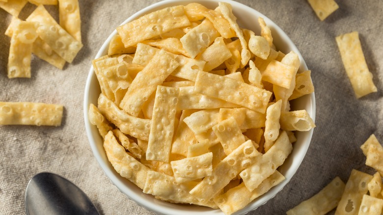 fried wonton strips in a bowl on a gray tablecloth