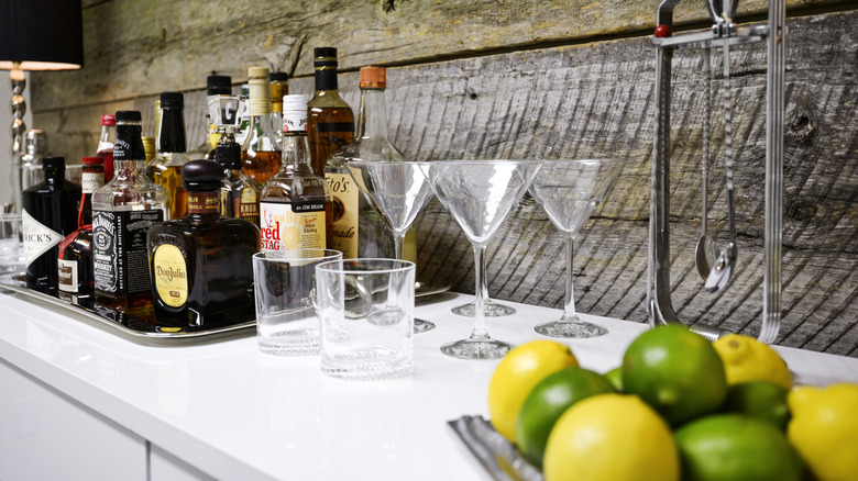 Bottles of alcohol on tray with drinking glasses