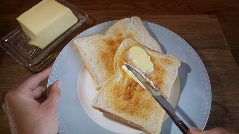 Spreading butter on toast