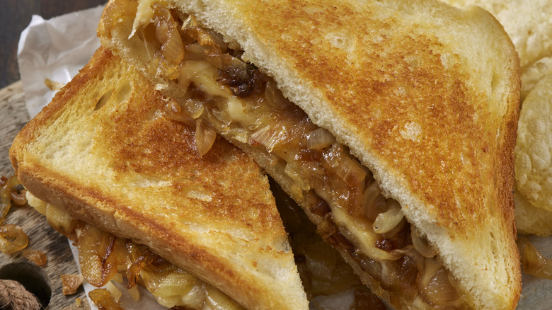 A french onion grilled cheese sandwich cut in half with golden toasted bread.