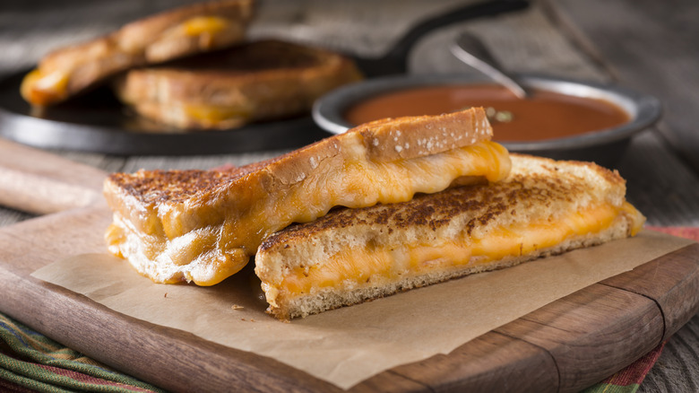 A grilled cheese sandwich in the foreground and in the background