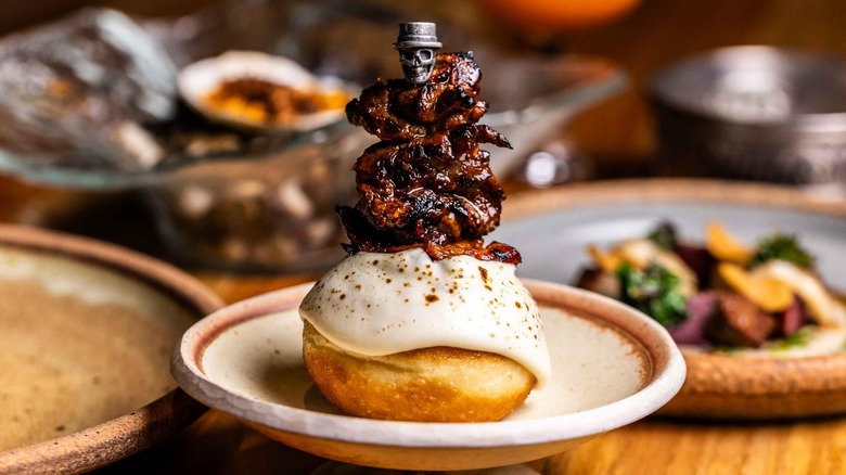 Skewered, roasted meat on top of an iced roll