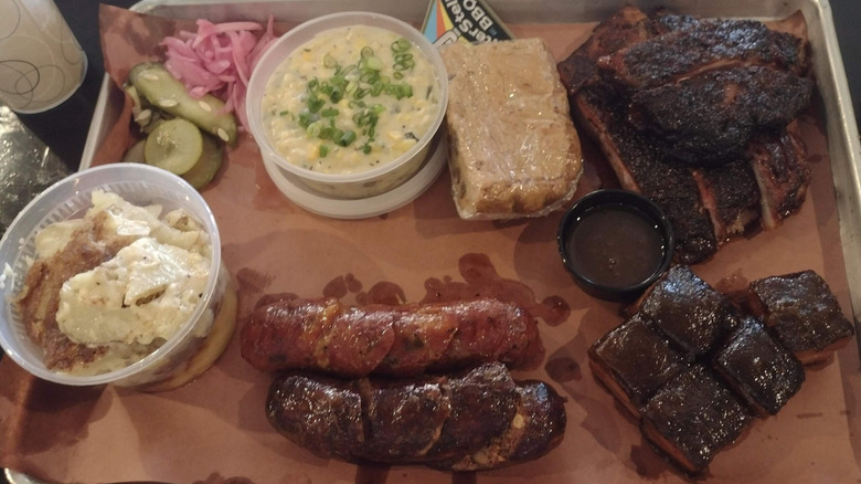 A tray of meats, sausages, and sides from InterStellar BBQ