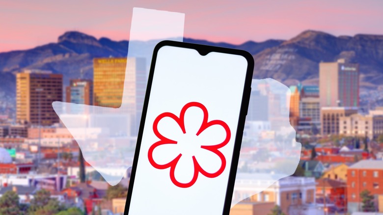 Phone with Michelin star background in front of state of Texas and Houston skyline