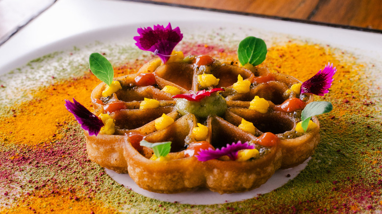 An Indian-inspired tart dusted with saffron powder and decorated with edible flowers