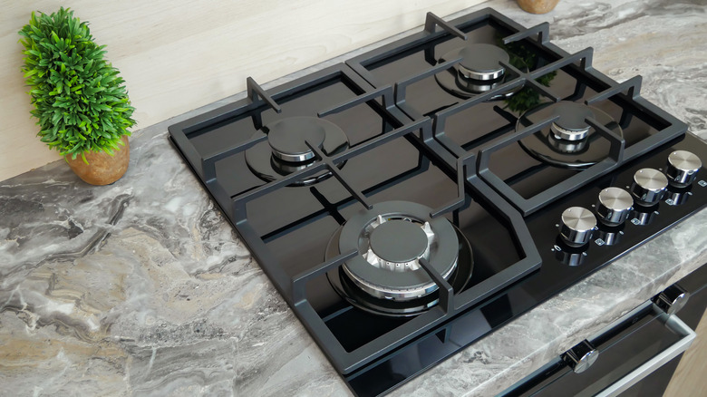 Commercial-style cooktop with large burners and knobs