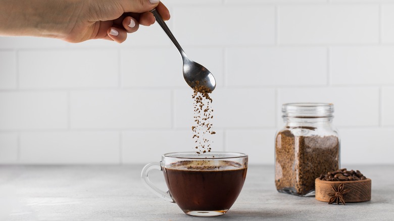 stirring spoonful of instant coffee into mug