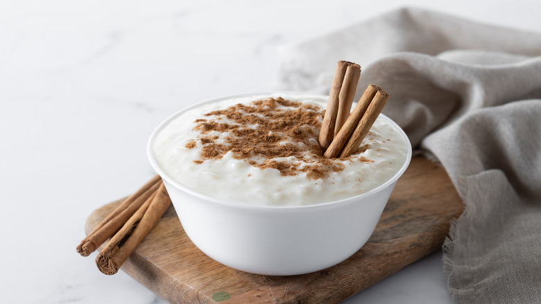 A bowl of rice pudding with cinnamon sticks