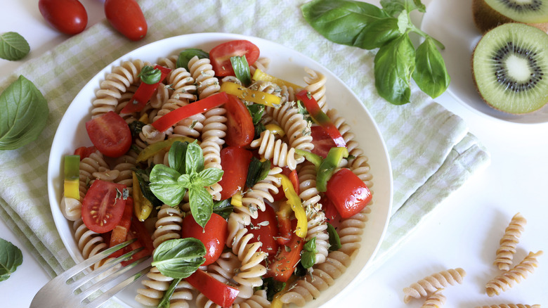 Whole wheat pasta salad with red bell peppers and tomatoes.