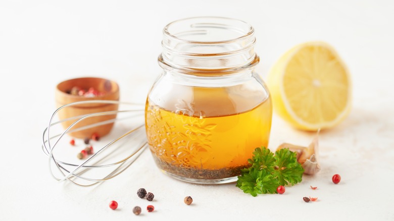 Vinaigrette Italia dalam toples kaca di samping pengocok dan lemon