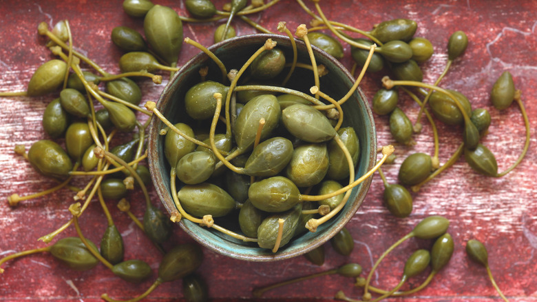 caper berries on red table