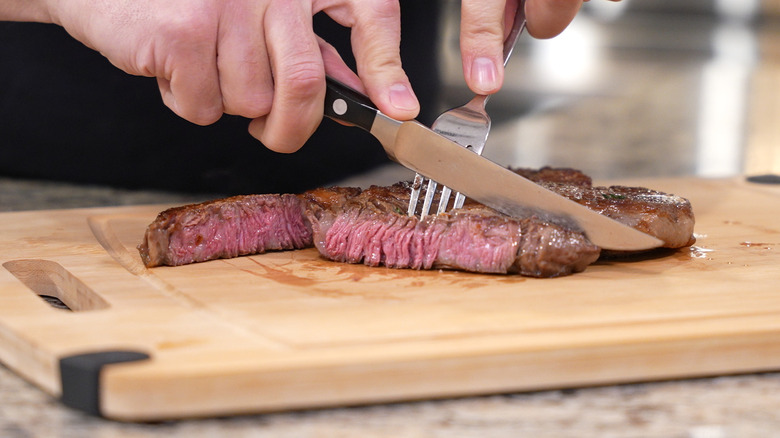 Person cutting into seared steak. 