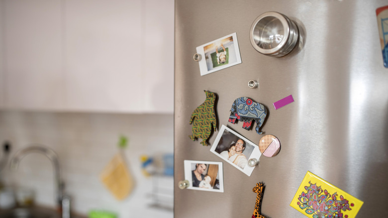 refrigerator door covered in magnets