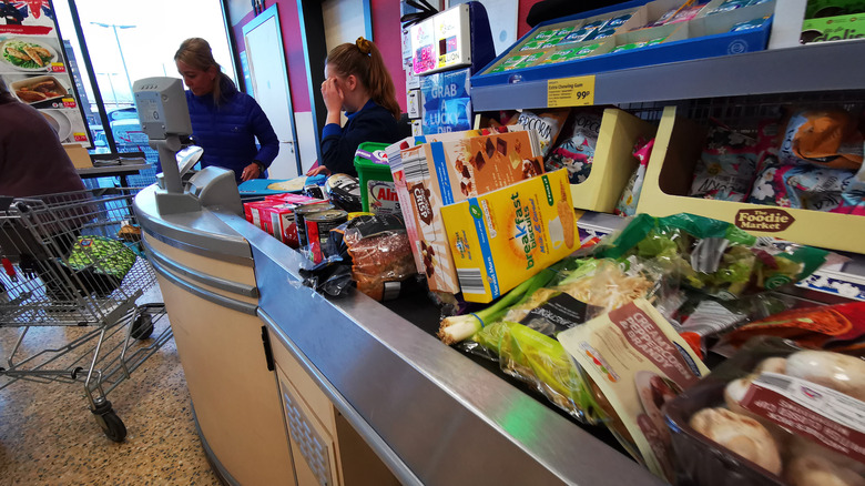 Cashier checking out groceries at Aldi.