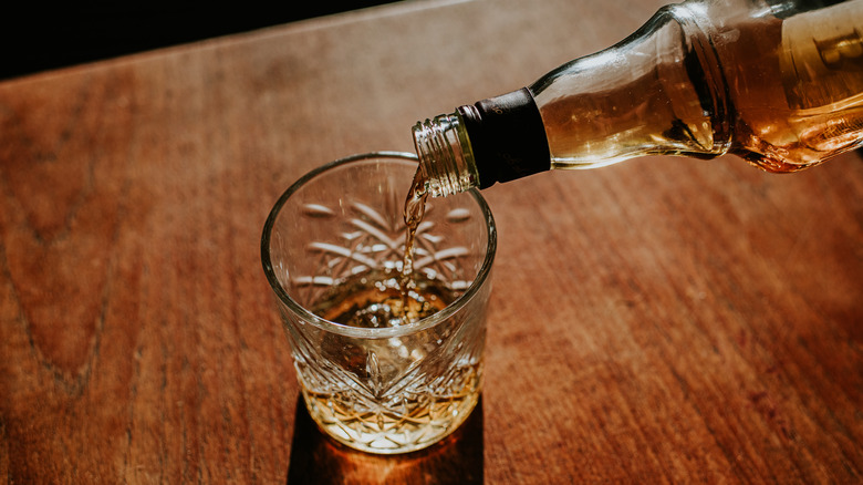 pouring whiskey into glass