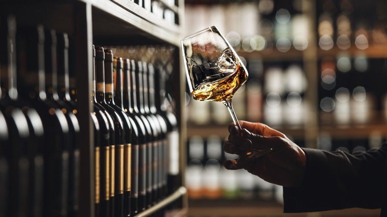 A sommelier tasting white wine in a cellar.