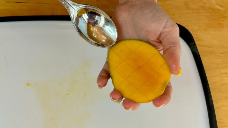 Spoon approaching mango
