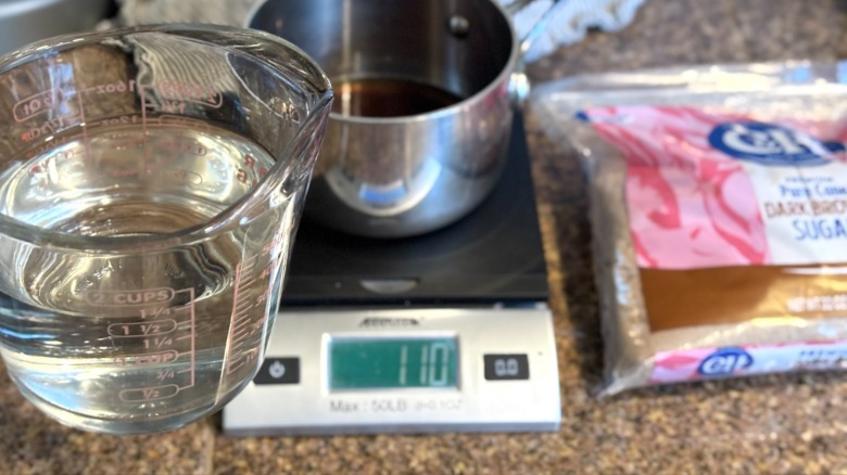 measuring cup of water in front of kitchen scale and pot