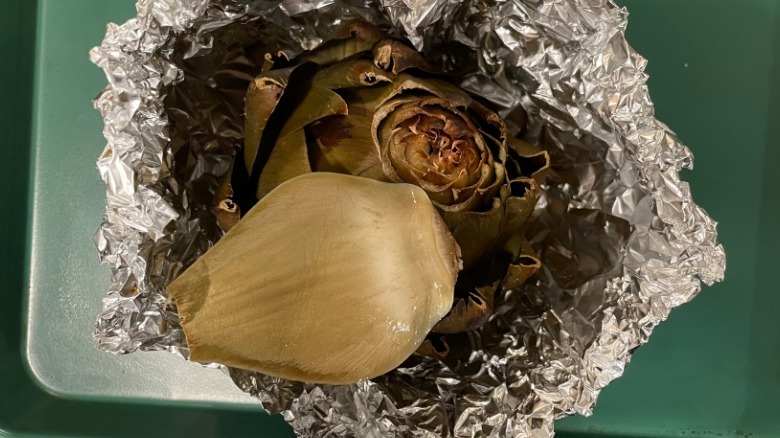 roasted artichoke and leaf checking for doneness