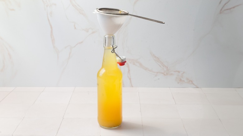Bottle topped with funnel and sieve