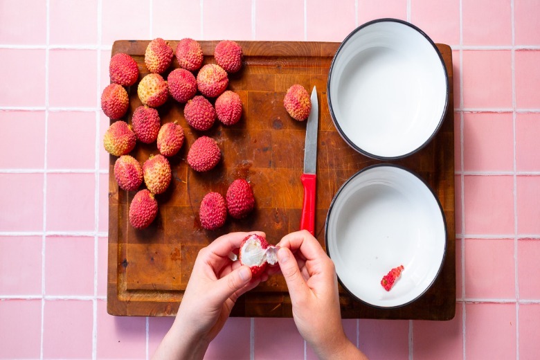 Peeling the skin off lychee