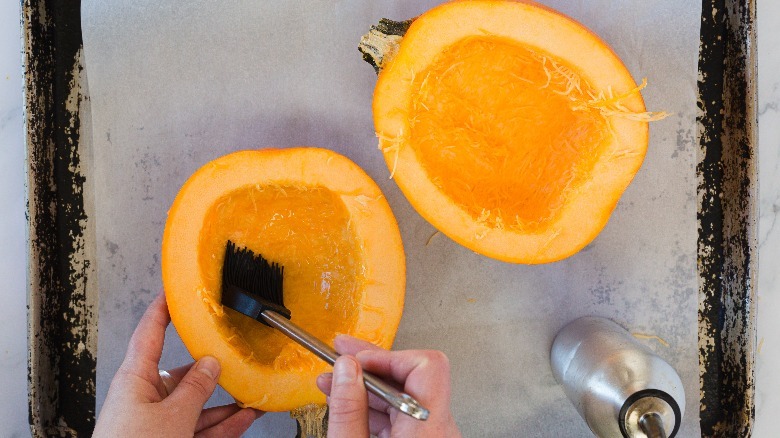 Brushing pumpkin with oil