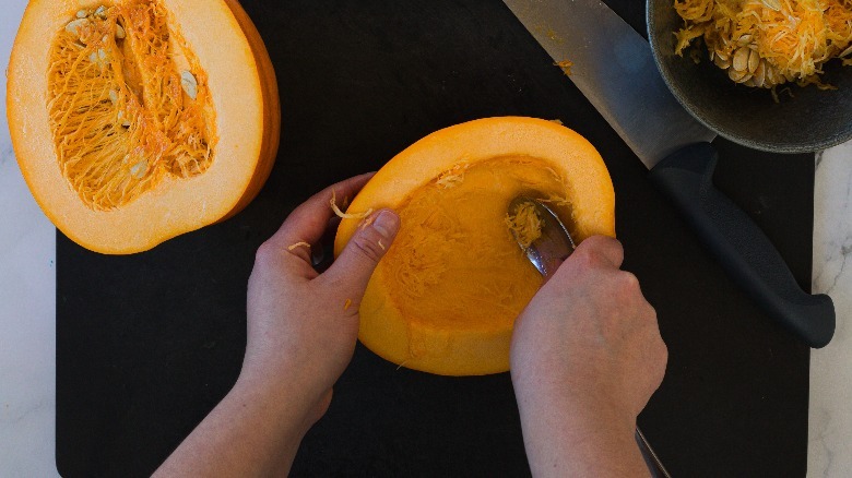 Scraping a pumpkin with spoon