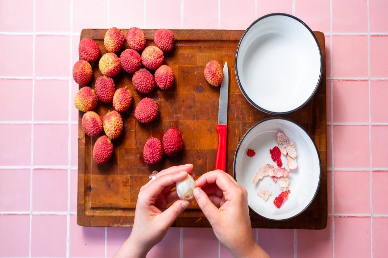 Peeling the skin off lychee