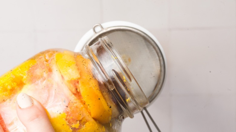 Pouring liquid into bottle from jar