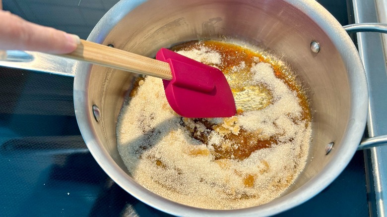 Pink spatula moving around caramel sauce