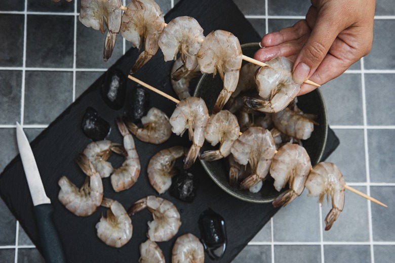 Threading shrimp on skewers