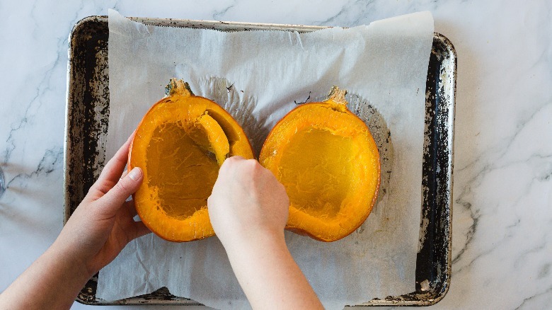 Scooping out flesh from pumpkin