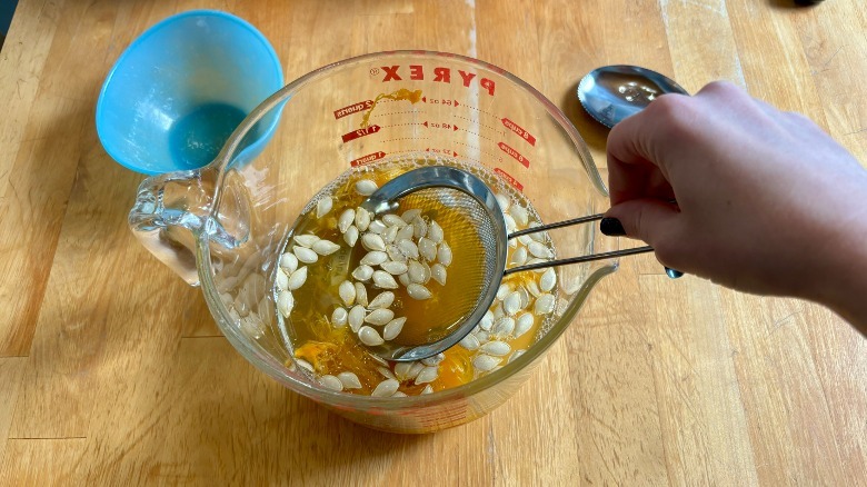 Pumpkin seeds being strained