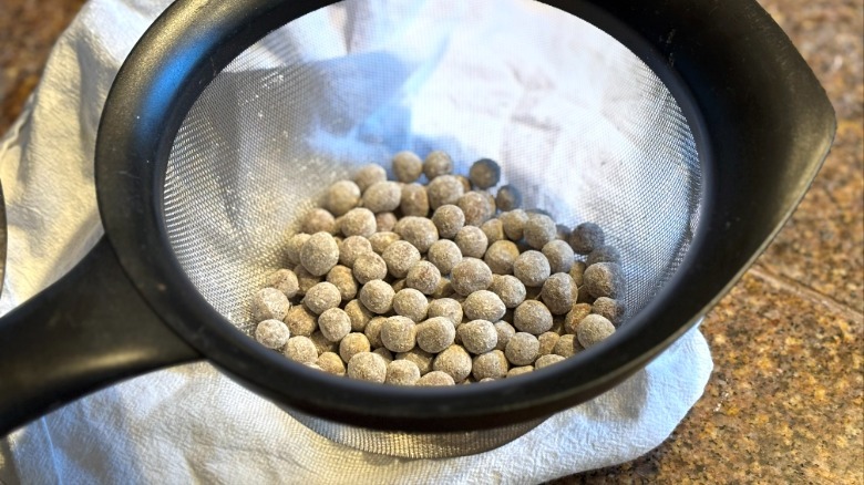 fresh boba coated in tapioca starch in metal strainer