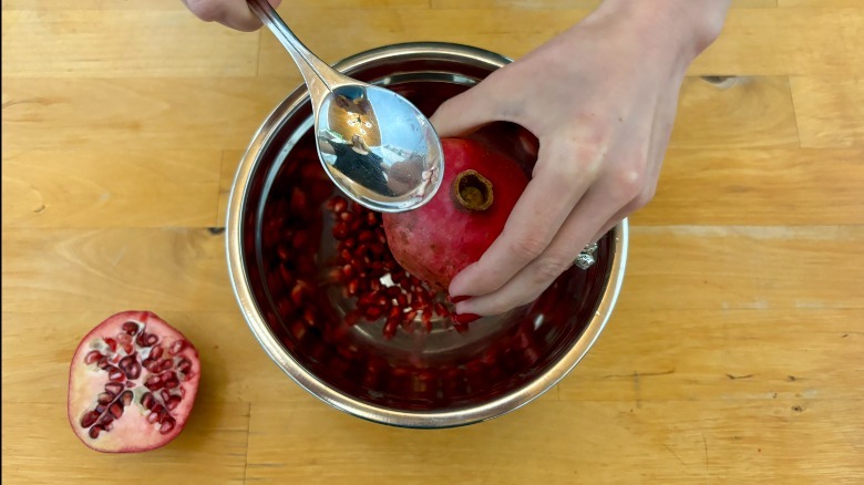 spoon hitting pomegranate